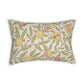 A decorative square throw pillow with a vintage botanical pattern of peaches and green leaves on a cream background, styled on a light gray sofa next to a dark green pillow and a knit blanket.