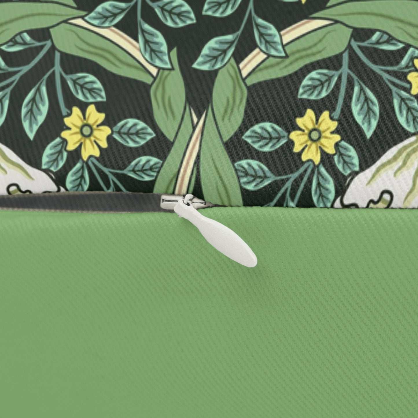 A rectangular lumbar cushion with a green William Morris & Co floral pattern on a green background, featuring a concealed beige zipper.