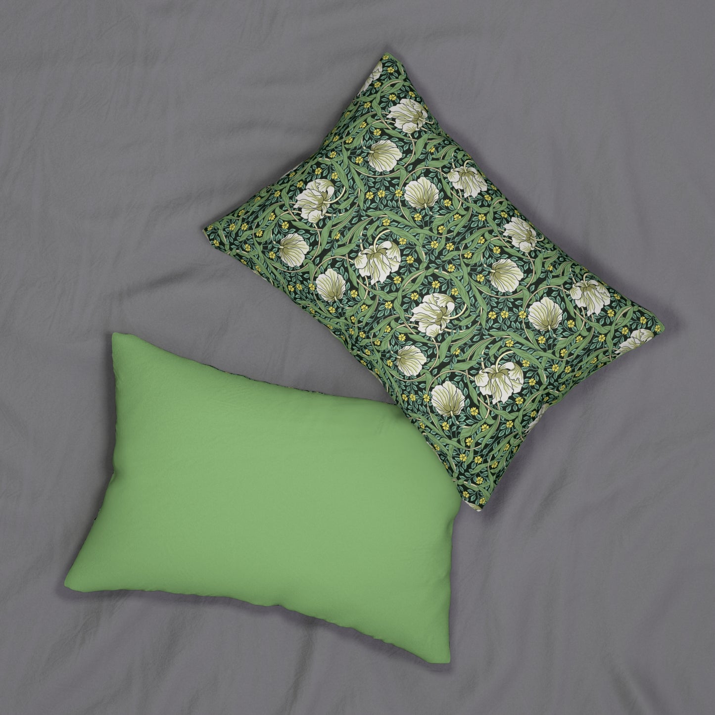 A rectangular lumbar cushion with a green William Morris & Co floral pattern on a green background, featuring a concealed beige zipper.