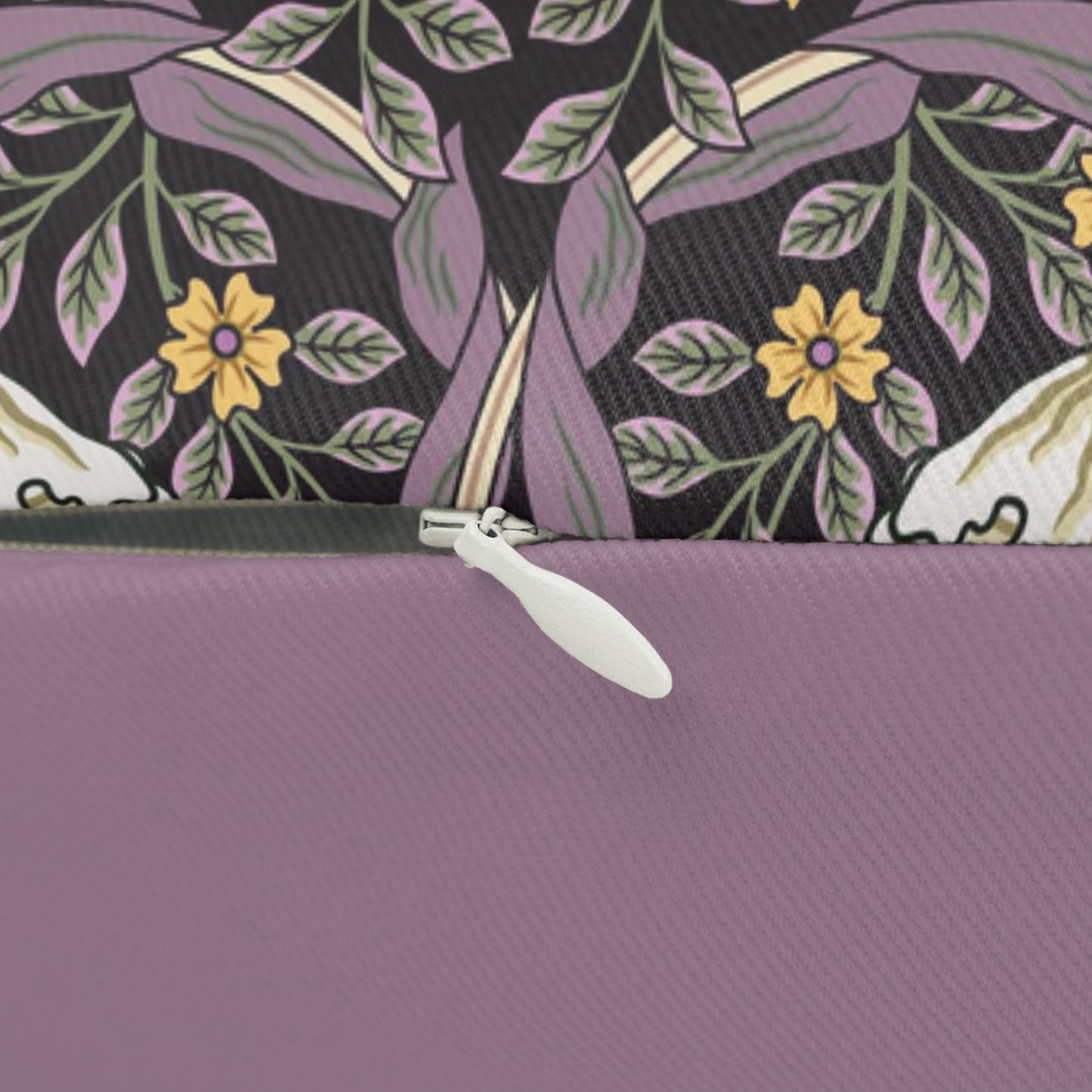 A rectangular lumbar cushion with a William Morris & Co floral pattern featuring pink and yellow flowers and green leaves on a dark background, with a concealed beige zipper.