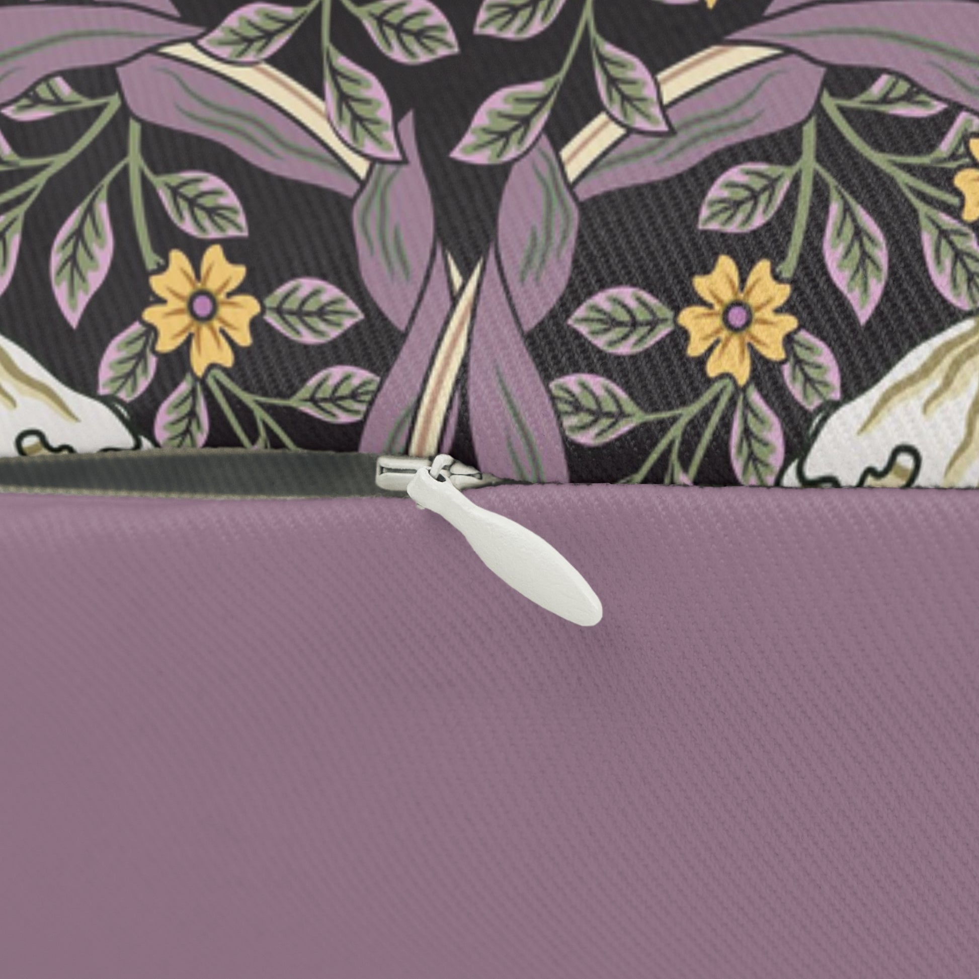 A rectangular lumbar cushion with a William Morris & Co floral pattern featuring pink and yellow flowers and green leaves on a dark background, with a concealed beige zipper.