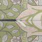 Close-up of a zipper with a white pull tab and black zipper tape, set against a patterned fabric background with green leaves and pink floral motifs.