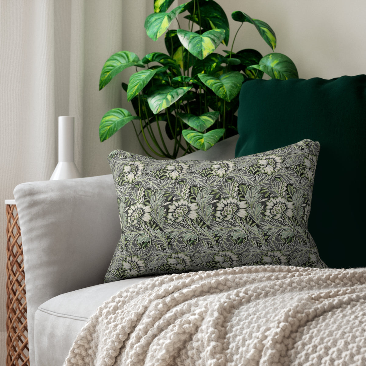 Decorative pillow with floral pattern on a couch next to a plant
