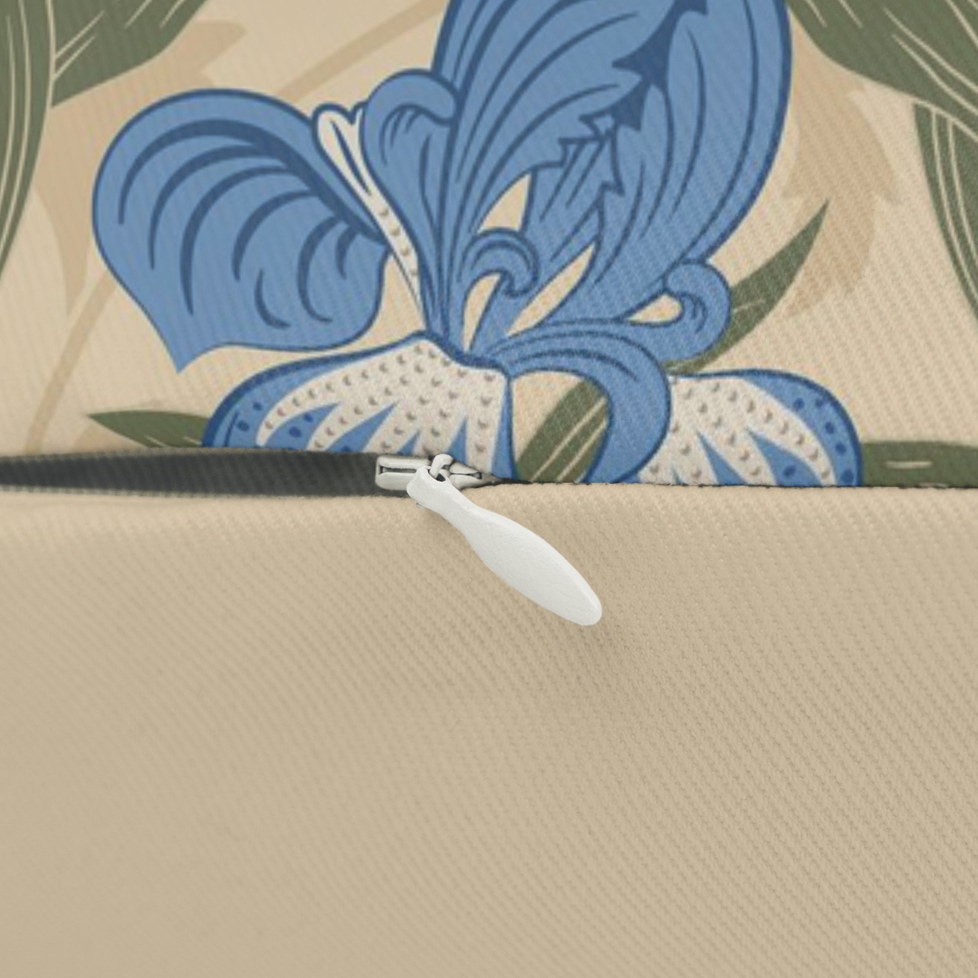 A rectangular lumbar cushion with a William Morris & Co floral pattern featuring blue irises, beige, and green colours on a white background with a concealed zipper.