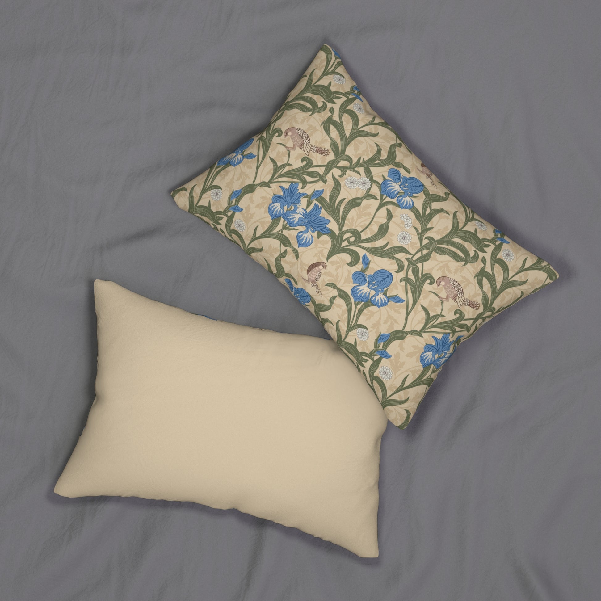 A rectangular lumbar cushion with a William Morris & Co floral pattern featuring blue irises, beige, and green colours on a white background with a concealed zipper.