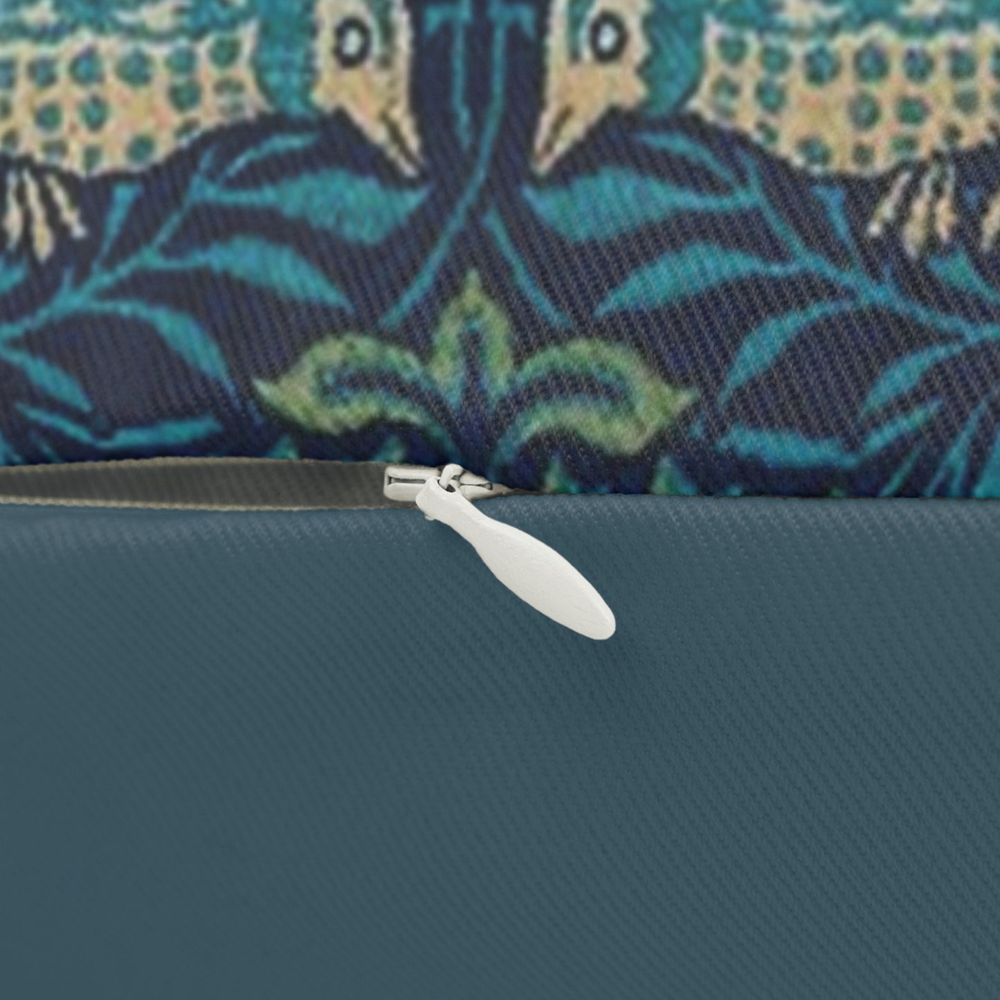 A rectangular lumbar cushion with a blue floral and animal pattern inspired by William Morris's art.