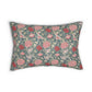 A rectangular decorative throw pillow featuring a dense floral and botanical pattern in pink, coral, and cream on a muted blue-green background, shown against a plain white studio backdrop.