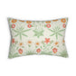 A rectangular lumbar throw pillow featuring a botanical pattern of green leaves and orange, red, and white flowers on a textured cream background.