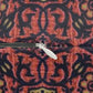 A rectangular decorative throw pillow featuring a dense, symmetrical Art Nouveau William Morris & Co pattern with stylised trees, leaves, and birds in coral pink, olive green and mustard yellow on a dark navy background.