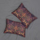Two square decorative throw pillows with an intricate floral and bird pattern in pink, orange, green, and dark purple, arranged on a gray fabric background.