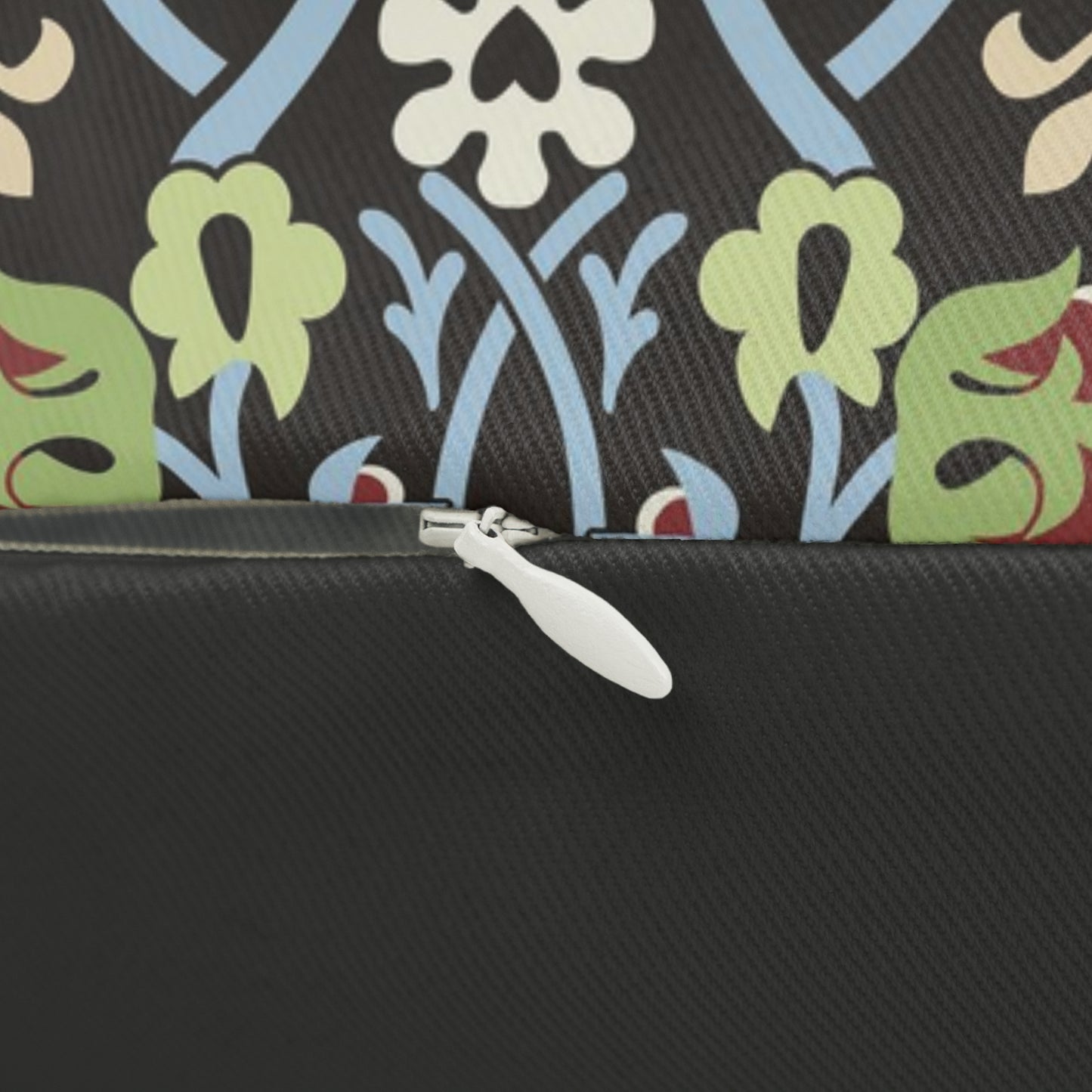 A rectangular lumbar cushion with a William Morris & Co floral and geometric pattern in multiple colours, including blue, beige, and green, with a concealed beige zipper.