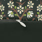 A rectangular lumbar cushion with a floral William Morris & Co pattern in red, green, and blue hues, featuring a hidden beige zipper.