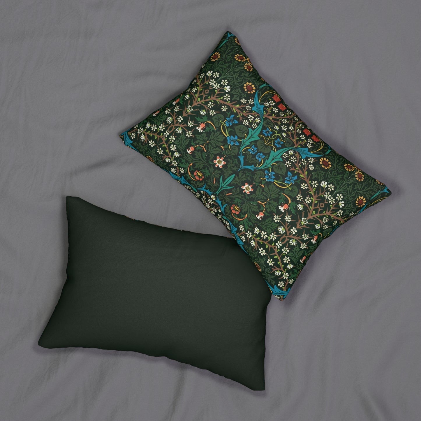 A rectangular lumbar cushion with a floral William Morris & Co pattern in red, green, and blue hues, featuring a hidden beige zipper.