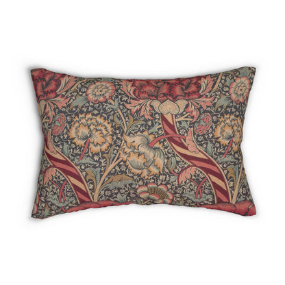 A rectangular lumbar cushion with a red and green William Morris & Co floral pattern on a textured background, featuring a concealed beige zipper.