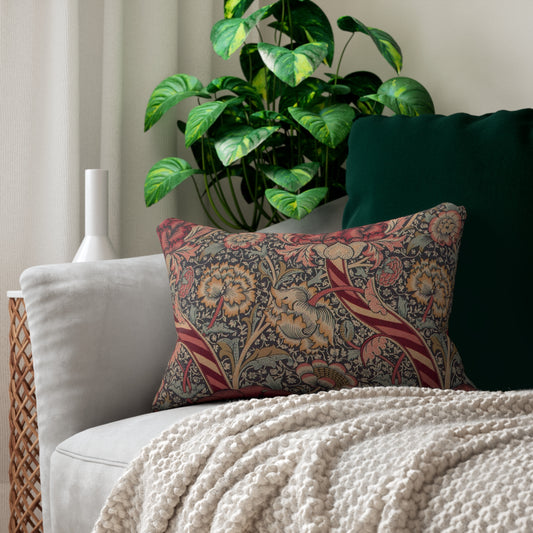 A rectangular lumbar cushion with a red and green William Morris & Co floral pattern on a textured background, featuring a concealed beige zipper.