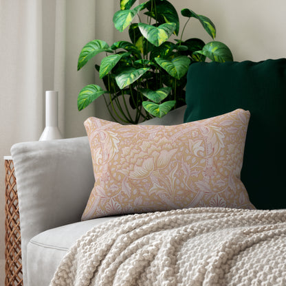 Pink patterned pillow on a gray sofa with a plant in the background