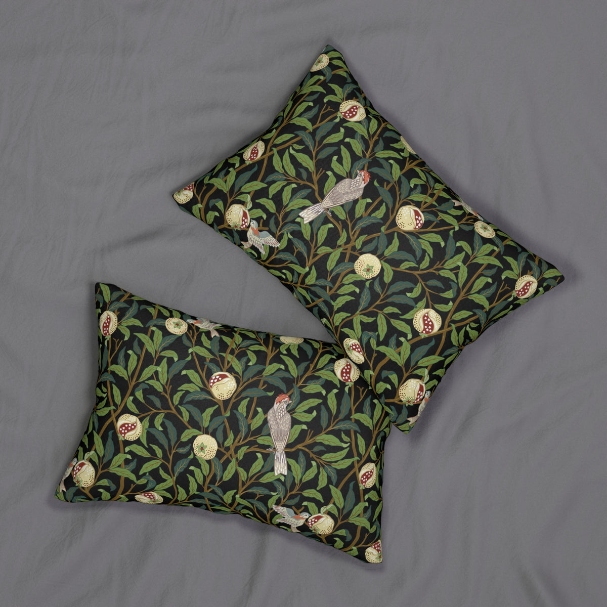 Two square decorative throw pillows with a dark green and black botanical pattern featuring pomegranate seeds, leaves, and birds, displayed on a gray fabric background.