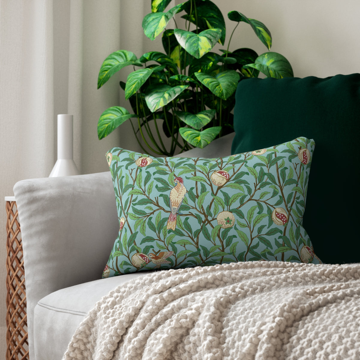 Decorative pillow with green shamrock pattern on a couch with a plant in the background