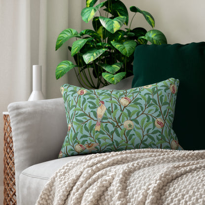 Decorative pillow with green shamrock pattern on a couch with a plant in the background