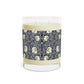 A clear candle with a lavender and sage William Morris & Co design called Pimpernel on the glass lid, alongside a brown cardboard lid with product information.