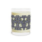 A clear candle with a lavender and sage William Morris & Co design called Pimpernel on the glass lid, alongside a brown cardboard lid with product information.