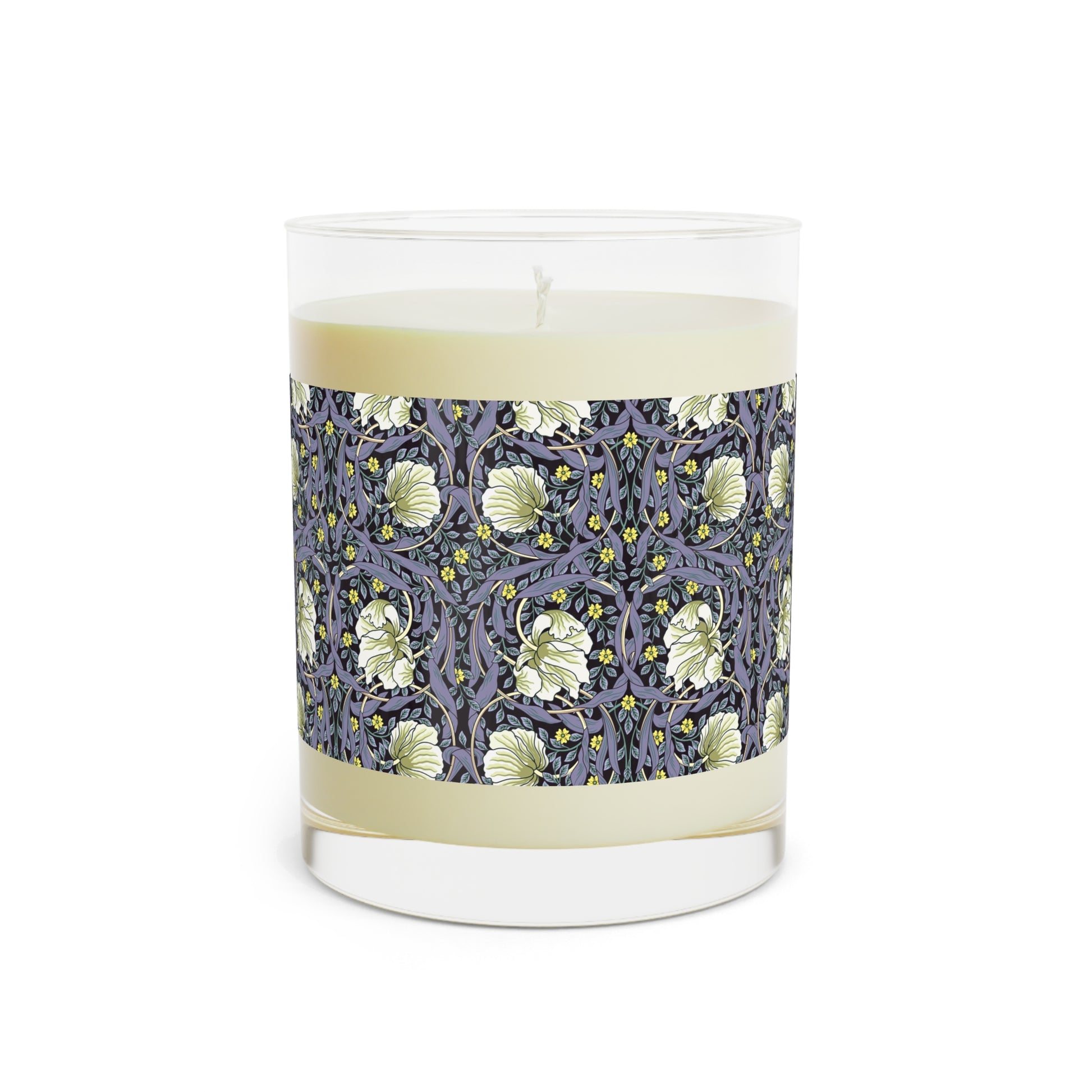 A clear candle with a lavender and sage William Morris & Co design called Pimpernel on the glass lid, alongside a brown cardboard lid with product information.