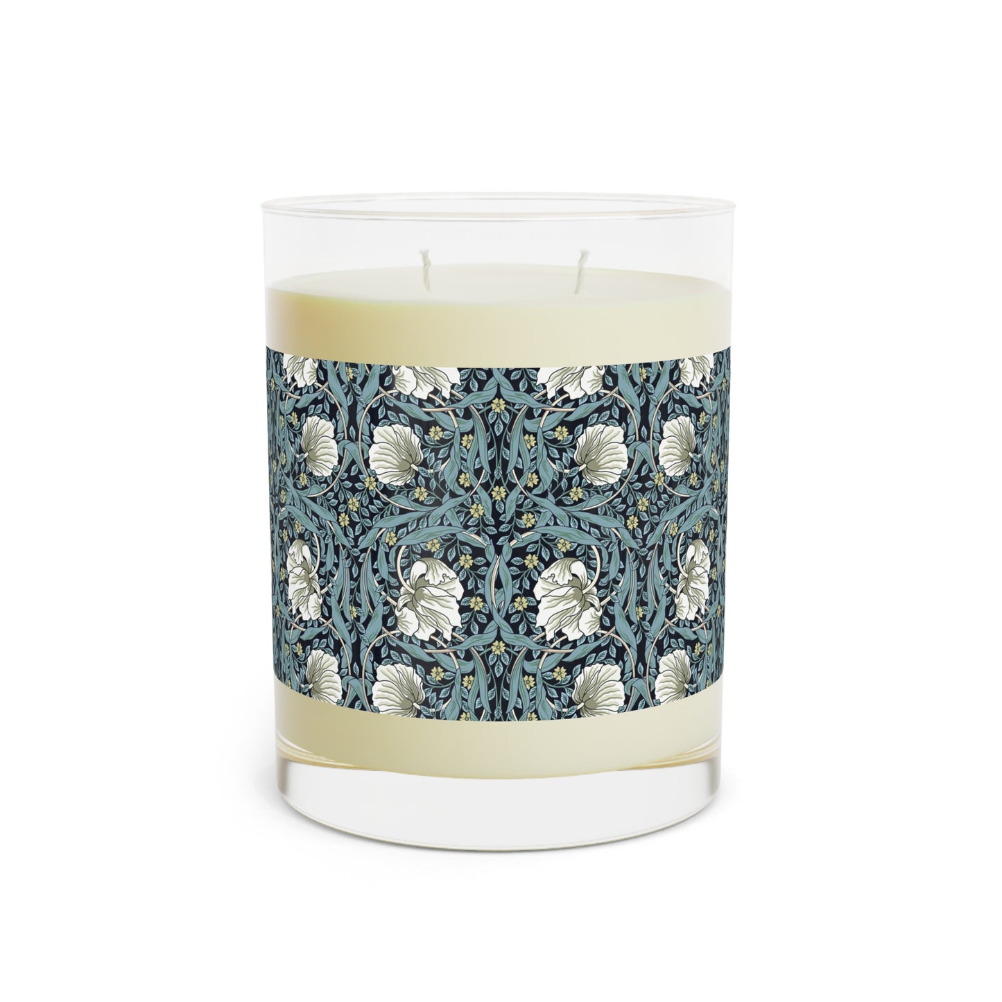 A clear glass candle with a William Morris & Co floral patterned lid and a label that reads 'Seventh Ave White Tea & Fig' alongside a brown cardboard lid.