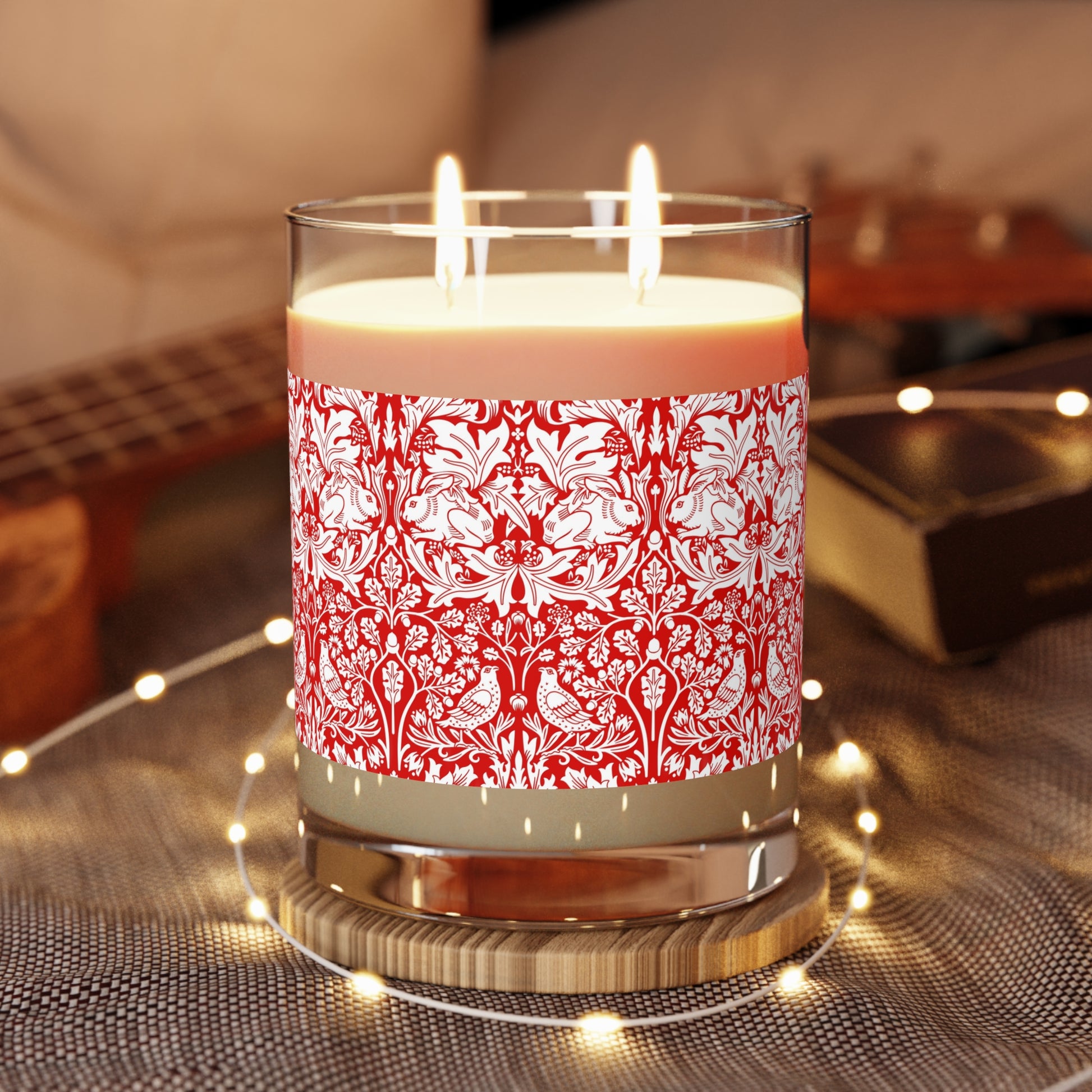 Candle with red floral pattern and wooden lid on a white background