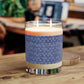 Candle with a blue patterned label on a wooden surface