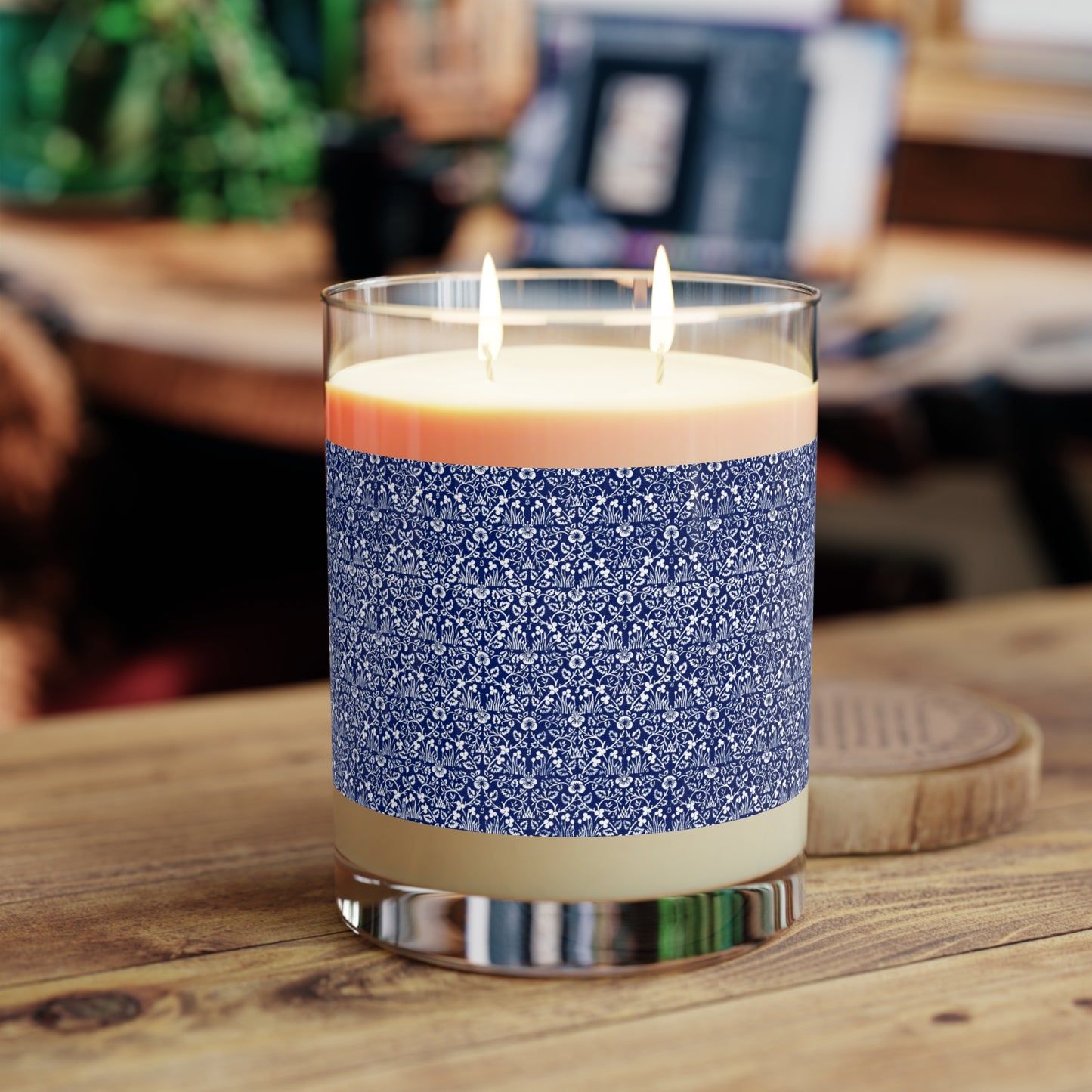 Candle with a blue patterned label on a wooden surface