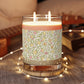 Candle with floral pattern on a wooden coaster with blurred background