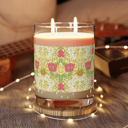 Decorative candle with floral pattern on a wooden coaster, surrounded by string lights.