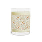 Candle with decorative label featuring birds and flowers on a white background
