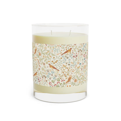 Candle with decorative label featuring birds and floral patterns on a white background