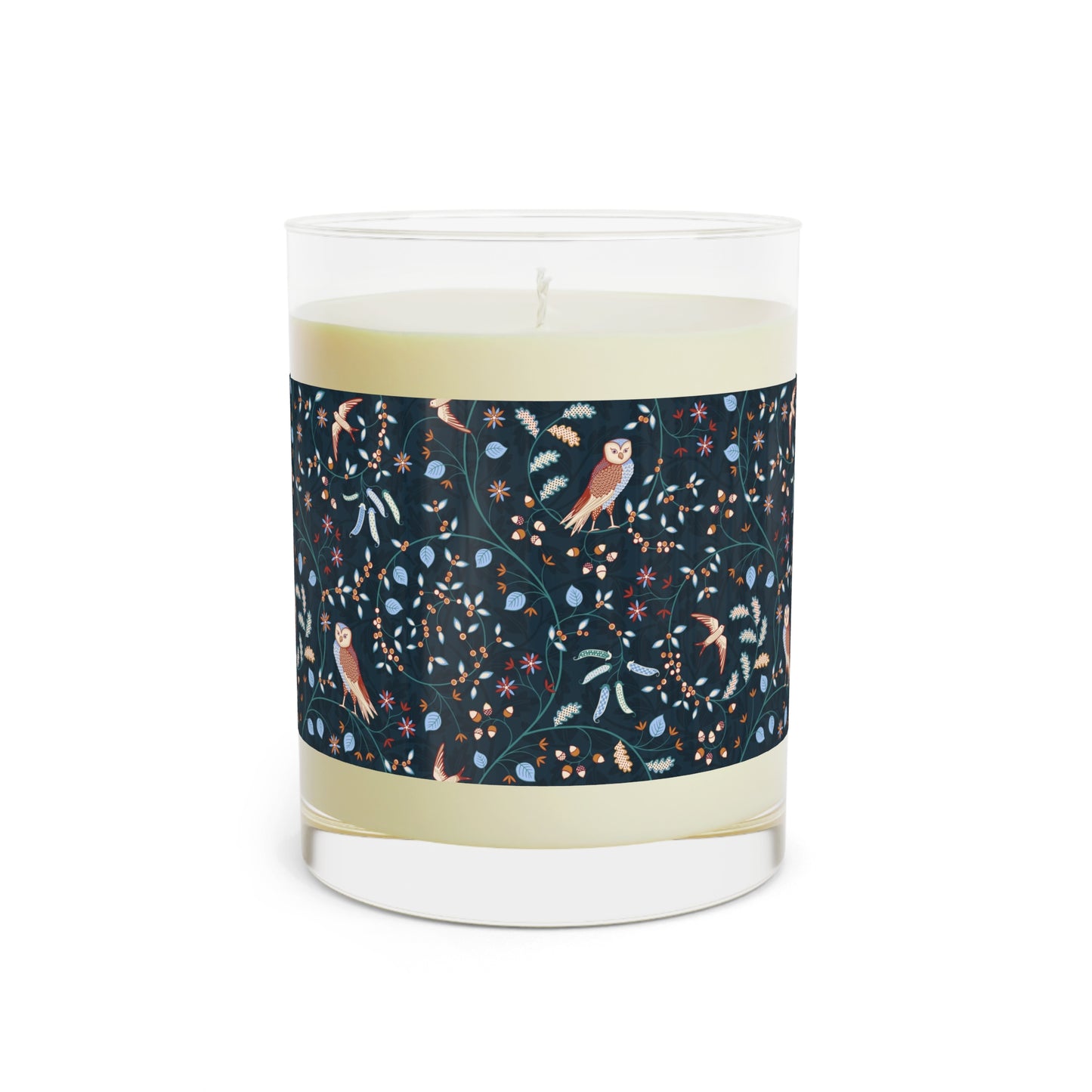 Candle with a decorative label featuring birds and floral patterns on a white background