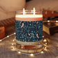Candle with a decorative label on a wooden surface with string lights