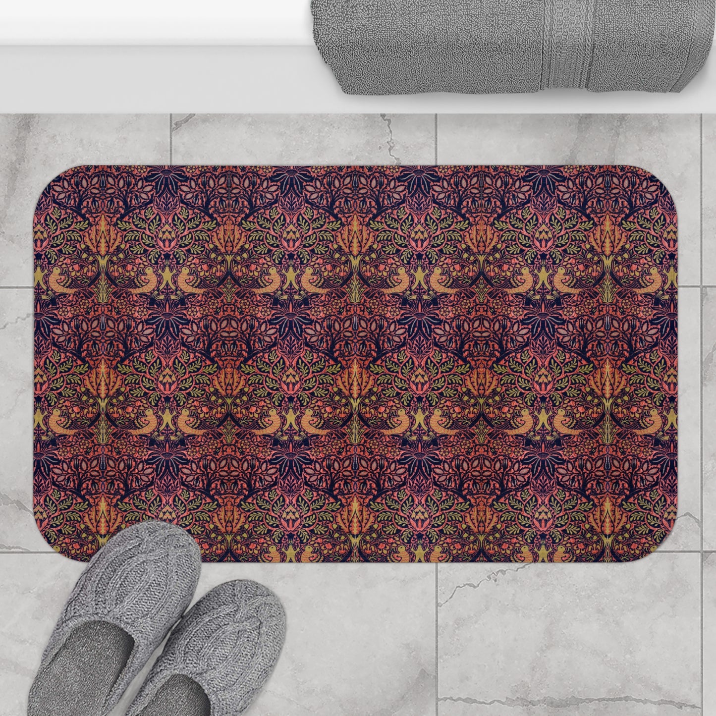 Decorative bath mat with a colourful pattern on a tiled floor with slippers and a bath mat.