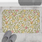 Floral patterned rug on a tiled floor with slippers and a towel.