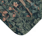 A microfibre bath mat featuring an intricate design of a deer in a forest setting, inspired by the William Morris tapestry.