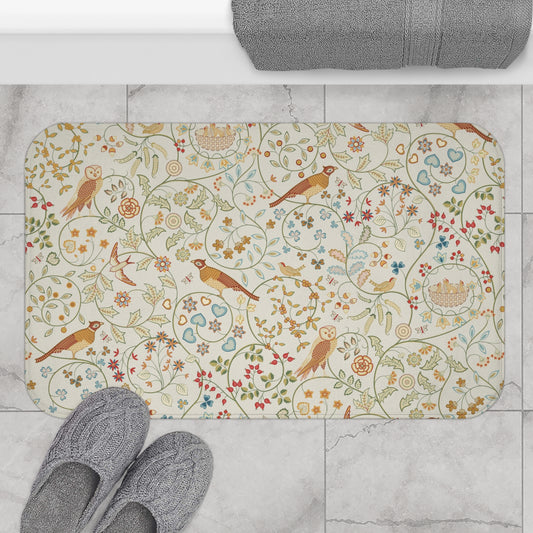 A microfibre bath mat with a floral and bird pattern inspired by William Morris, in a beige, green, and brown color palette.