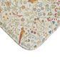 A microfibre bath mat with a floral and bird pattern inspired by William Morris, in a beige, green, and brown color palette.