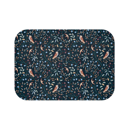 Patterned doormat with birds and foliage on a dark blue background
