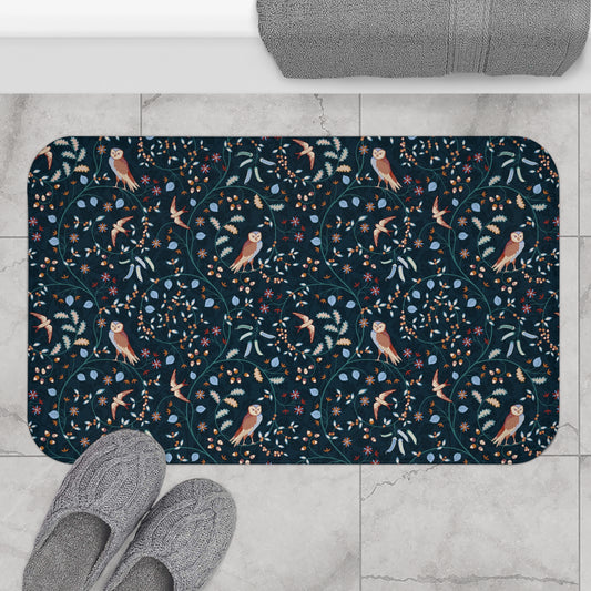 Decorative doormat with owl and floral pattern on a tiled floor with slippers.