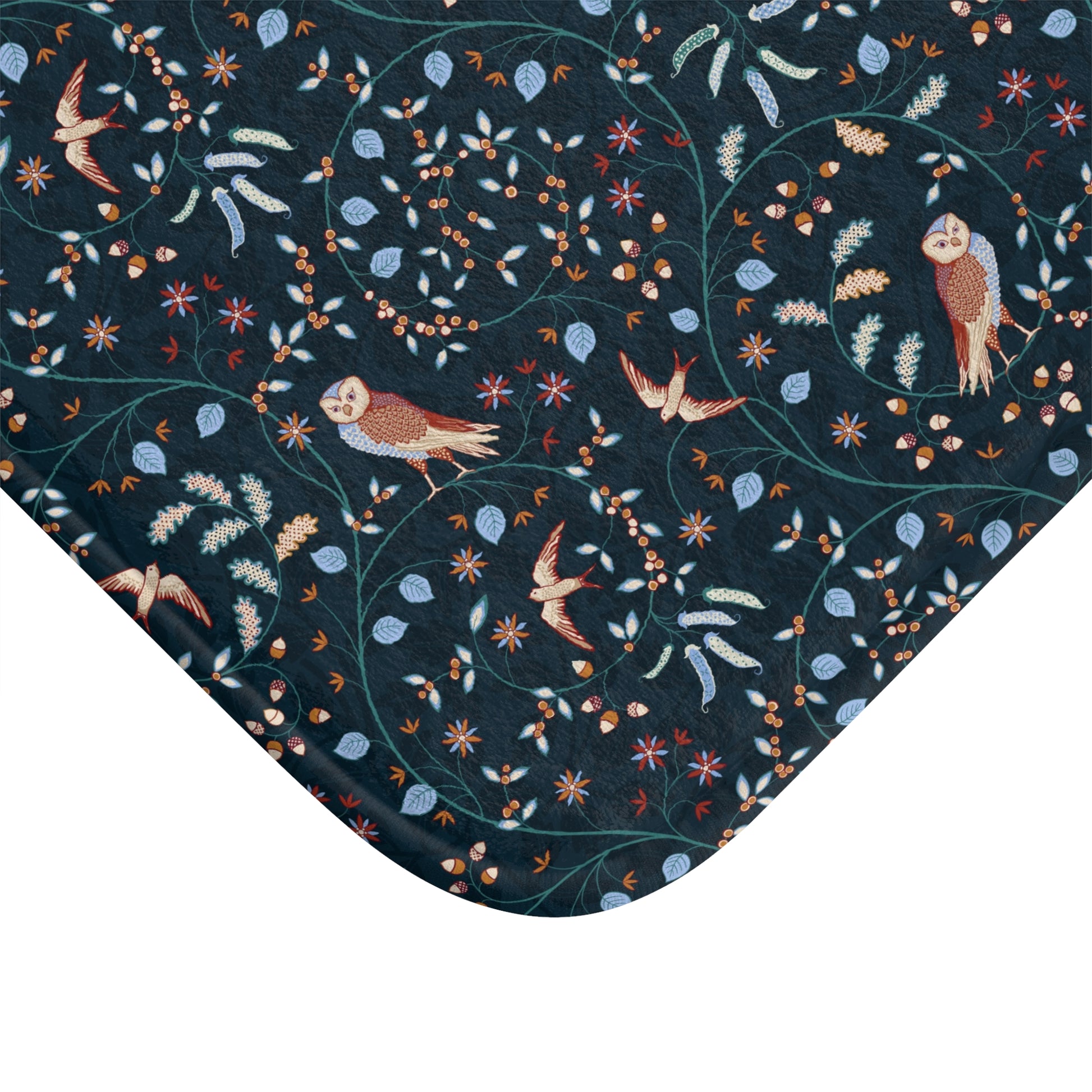 Patterned fabric with birds and foliage on a dark blue background