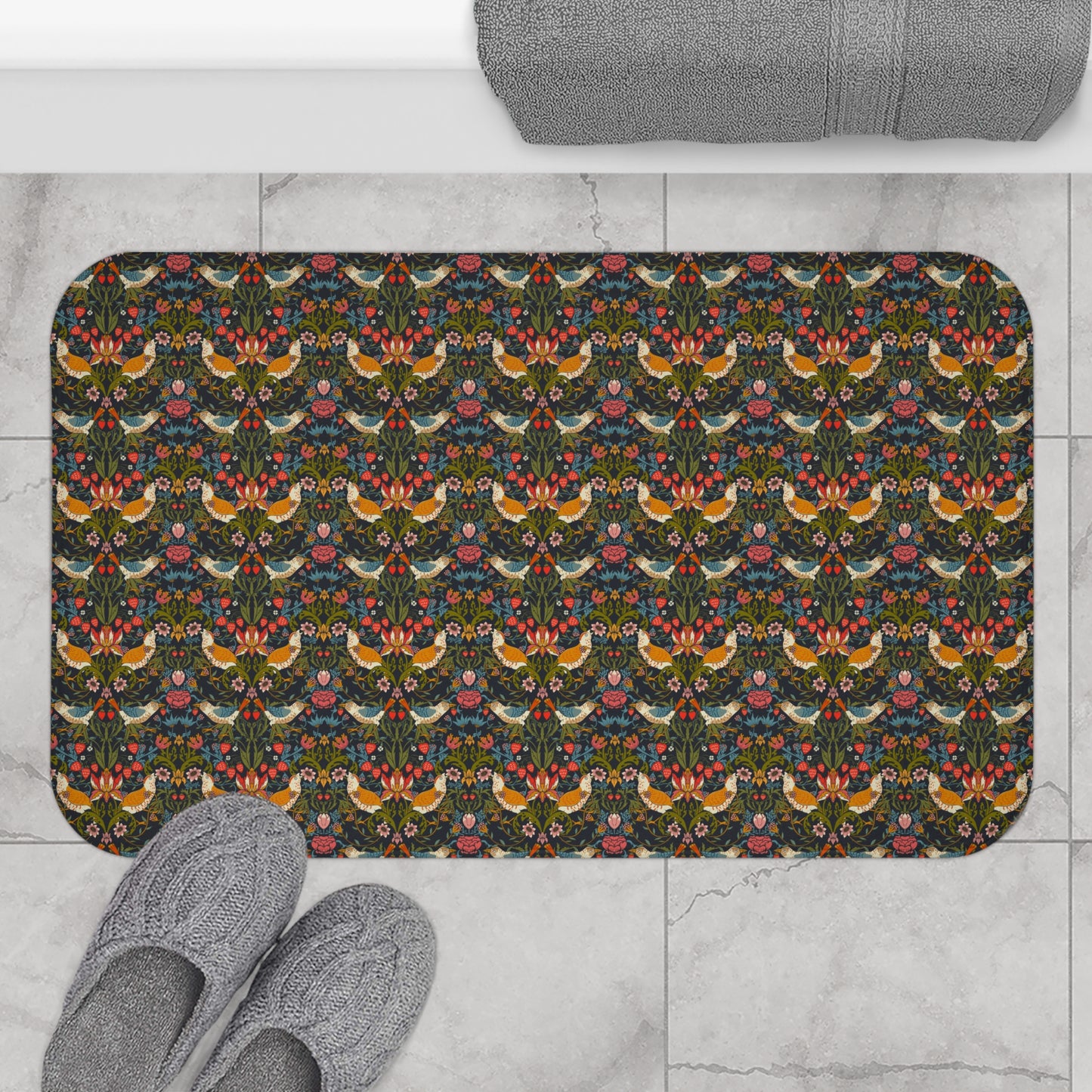 Decorative doormat with floral and bird pattern on a tiled floor with slippers.