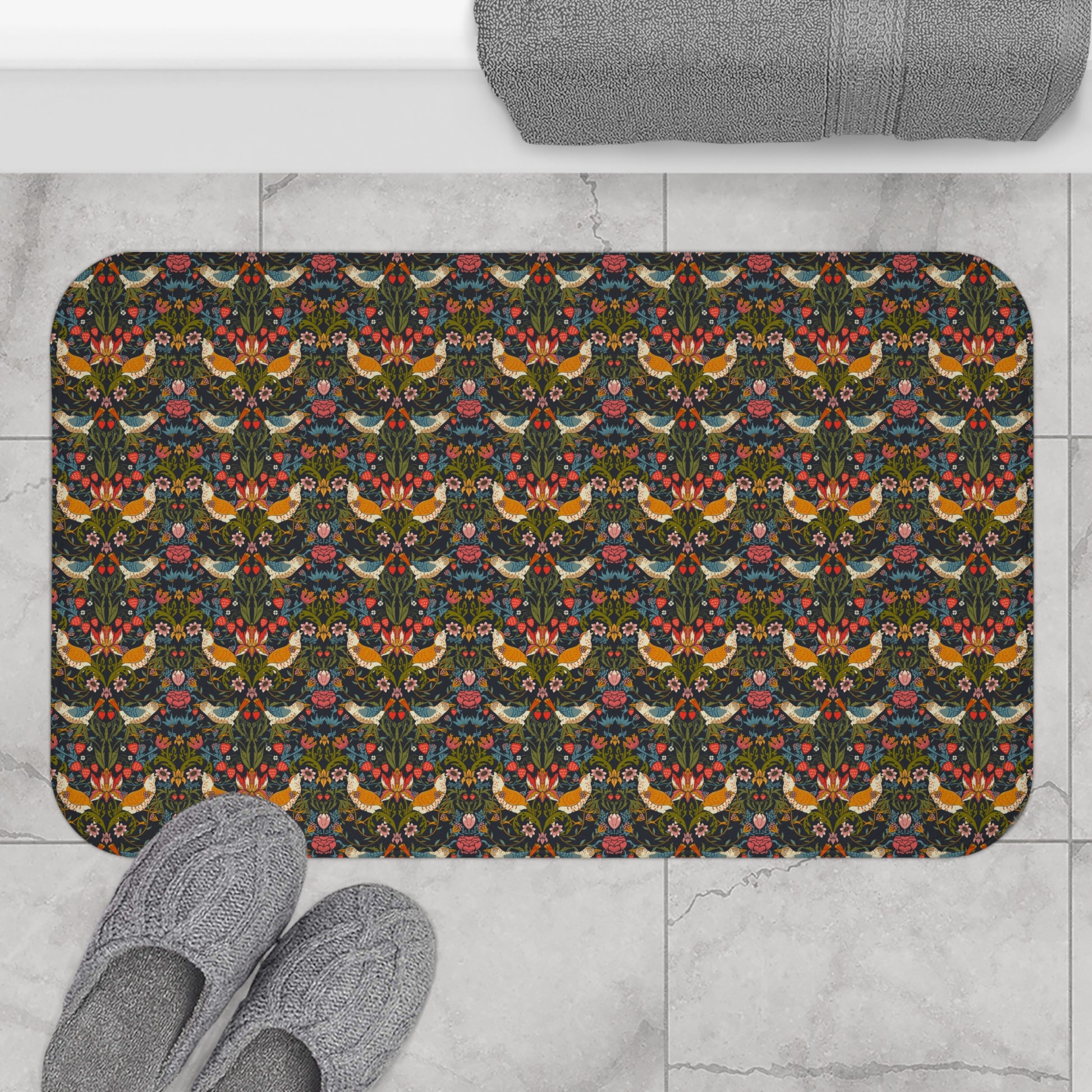 Decorative doormat with floral and bird pattern on a tiled floor with slippers.