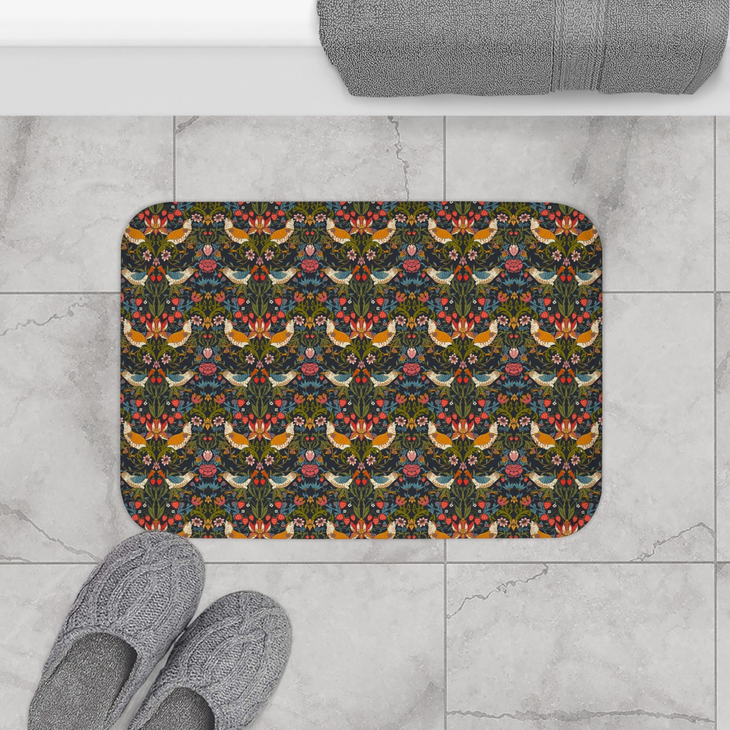 Decorative doormat with floral and bird pattern on a marble floor with slippers and a towel.