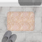 A rectangular microfibre bath mat with a floral pattern inspired by William Morris, in beige, pink and orange colours.