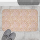A rectangular microfibre bath mat with a floral pattern inspired by William Morris, in beige, pink and orange colours.