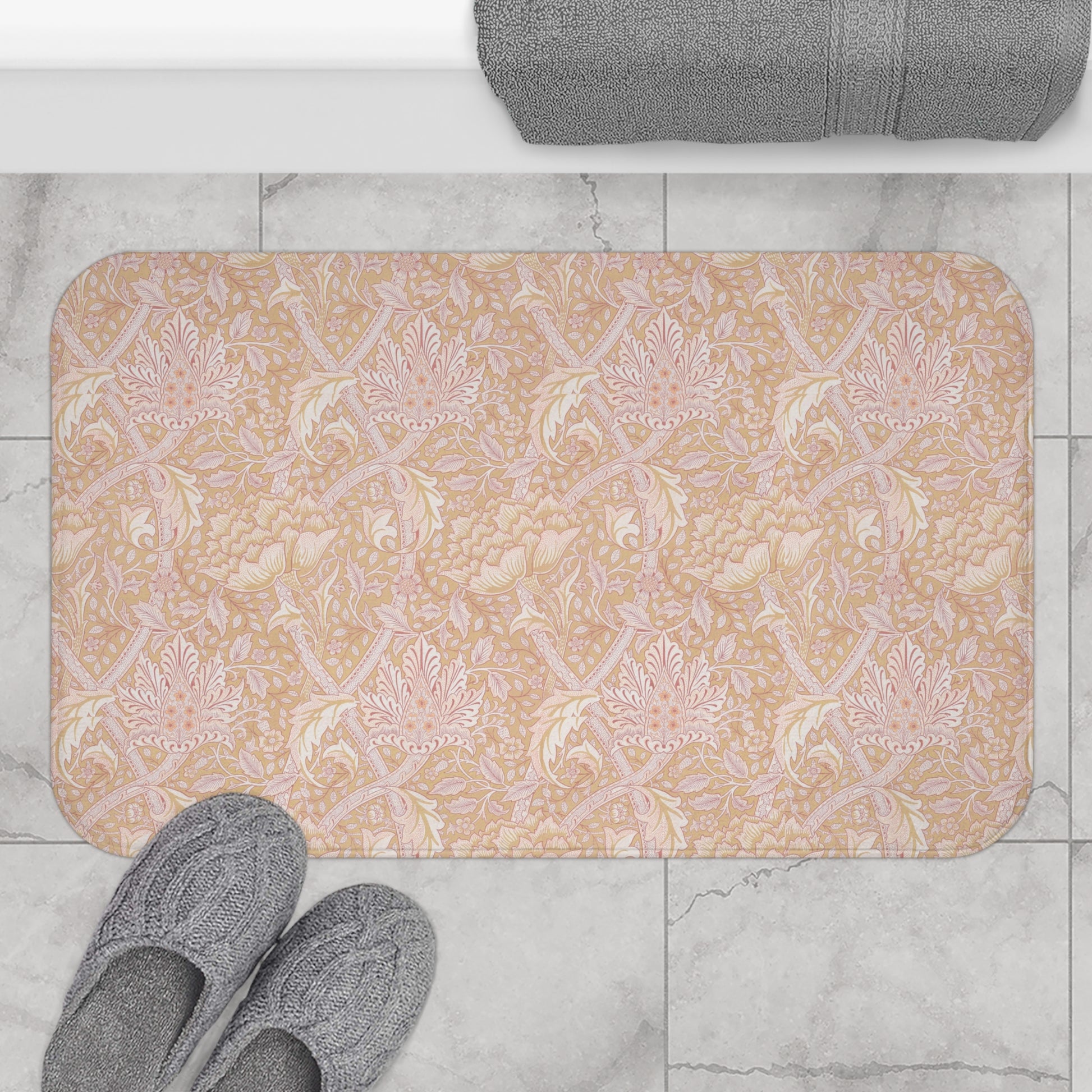 A rectangular microfibre bath mat with a floral pattern inspired by William Morris, in beige, pink and orange colours.